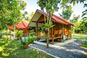 drewniany dom z czerwonym dachem w obiekcie Taluangjit Resort&Garden w mieście Kiriwong