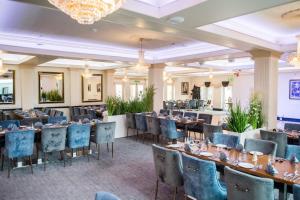 jadalnia ze stołami i krzesłami oraz żyrandolem w obiekcie Clifton Park Hotel - Exclusive to Adults w mieście Lytham St Annes