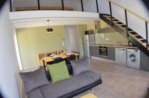 a living room with a couch and a kitchen at Le Clos des Taulelles gîte Le Figuier in Saint-Privat-de-Champclos