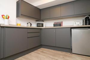 a kitchen with gray cabinets and a counter top at TOWN CENTRE apartment with parking in Padstow
