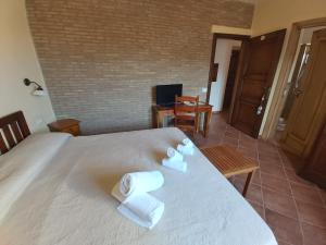 a hotel room with a bed, chair, and table in it at Agriturismo Passo dei Briganti in Agrigento