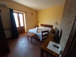 a bedroom with a bed and a table with a desk at Agriturismo Passo dei Briganti in Agrigento