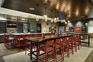 a restaurant with a long bar with red chairs at Holiday Inn St. George Convention Center, an IHG Hotel in St. George