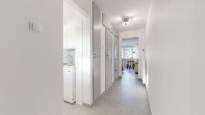 Un pasillo con paredes blancas y una cocina blanca. en Apartament Świdnicka, en Wroclaw