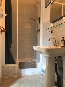 a bathroom with a sink and a shower at Hôtel de Paris Restaurant BISTRONOMY in Les Andelys