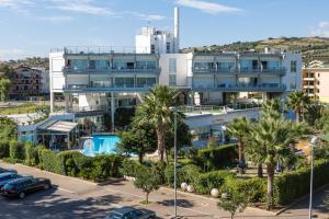 un grand bâtiment blanc avec une piscine et des palmiers dans l'établissement SeaPark SPA Resort, à Giulianova