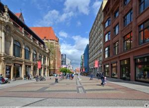 un grupo de personas caminando por una calle de la ciudad en Apartament Świdnicka, en Wroclaw