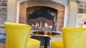 two yellow chairs in front of a fireplace at Hotel Relais Du Postillon in Antibes