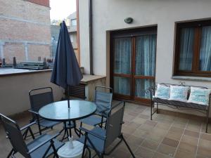 eine Terrasse mit einem Tisch, Stühlen und einem Sonnenschirm in der Unterkunft Apartameto Verena Deluxe in Guardiola de Berga