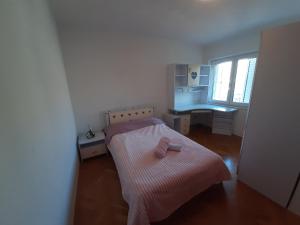 een kleine slaapkamer met een bed en een bureau bij FAMILY TIME in Split