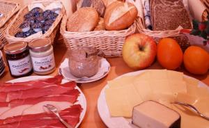 申瓦爾德的住宿－蘭德豪斯里納酒店，餐桌上摆放着奶酪、面包和食物篮子