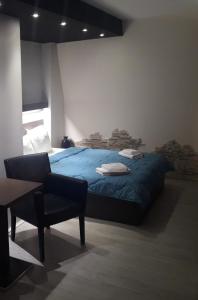 1 dormitorio con 1 cama azul y 1 silla en Prenoćište Konstantin 2008, en Niš