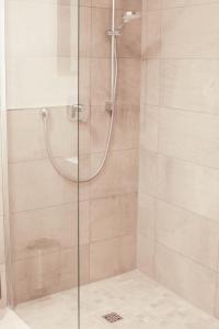 La salle de bains est pourvue d'une douche avec une porte en verre. dans l'établissement Voss-Haus, à Eutin