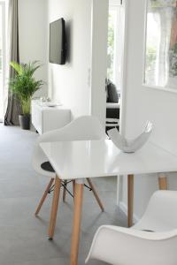 a white dining table and two white chairs in a room at Voss-Haus in Eutin