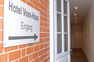 um sinal numa parede de tijolos ao lado de uma porta em Voss-Haus em Eutin