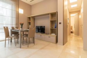 a dining room with a table and chairs and a television at Luxury Maison - Appartamento di lusso a 50m dalla spiaggia in Grottammare