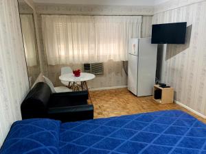 Zimmer mit einem Bett, einem Tisch und einem Kühlschrank in der Unterkunft DEPARTAMENTO COCA in Buenos Aires