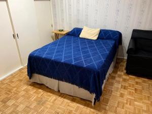 ein blaues Bett in einem Zimmer mit Holzboden in der Unterkunft DEPARTAMENTO COCA in Buenos Aires