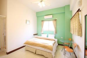 um quarto com uma cama e uma mesa de vidro em Penghu Jack Family B & B em Magong