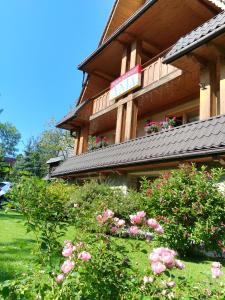 a building with pink flowers in front of it at Ania Wynajem Pokoi in Zakopane
