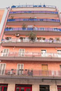 un alto edificio in mattoni rossi con finestre e balconi di My place a Bari