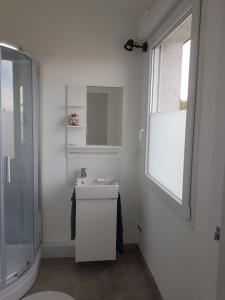 a white bathroom with a sink and a shower at L ATELIER in Courtisols