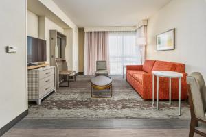 a hotel room with a couch and a tv at Holiday Inn Hotel & Suites Memphis-Wolfchase Galleria, an IHG Hotel in Memphis