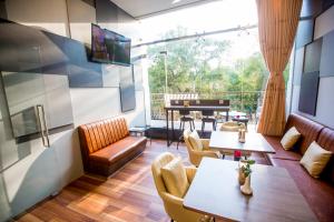 een kamer met een tafel en stoelen en een piano bij Prestige Residences at Golden Valley by Grand United Hospitality in Yangon