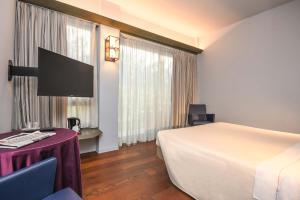 una camera d'albergo con letto, tavolo e TV di Hotel City a Desenzano del Garda