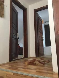 an empty room with two doors and a rug at Vila Denis in Costinesti