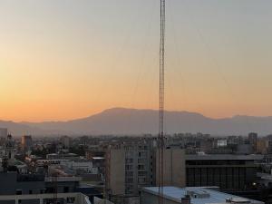 a view of a city at sunset with a tower at Metro U de Chile Santiago Centro in Santiago