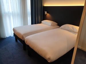 Una cama o camas en una habitación de ibis Styles Liege Guillemins