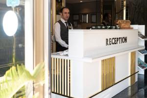 a man standing behind a reception counter in a store at Sky Kamer Hotel Antalya in Antalya