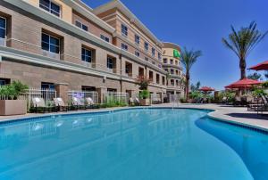 
a large swimming pool in front of a large building at Holiday Inn Ontario Airport - California, an IHG Hotel in Ontario
