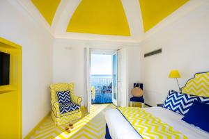 um quarto com uma cama e um tecto amarelo e branco em Imperati Suites by Alcione Residence em Positano