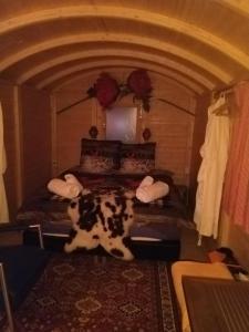 Une vache dormant sur un lit dans une pièce dans l'établissement Strandhotel Terschelling, à Formerum
