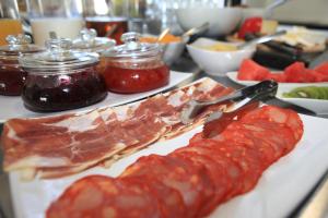 a plate of food with cured meats and sauce at O Abel Hotel rural in Bragança +33 photos