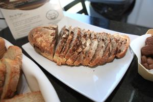 a sandwich on a white plate on a table with bread at O Abel Hotel rural in Bragança