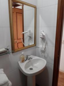 
a bathroom with a sink and a mirror at Hotel Casa Madero in Envigado
