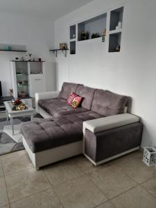 a brown couch in a living room with a table at Casa Mirela in Bucharest