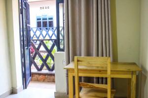 a wooden table and chair next to a balcony at Akagera Neighbors in Kabarondo