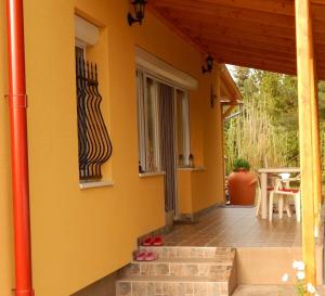 eine Veranda eines Hauses mit einem Tisch und einem Fenster in der Unterkunft Bükki Vendégház in Balatonmáriafürdő