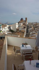a balcony with tables and chairs and a view of a city at Hostal Fornet Altea in Altea