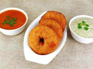 two donuts on a plate next to a bowl of soup at Hotel Prabha Palace in Ahmadnagar
