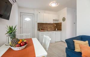 een keuken met een tafel en een fruitschaal bij Apartments Dora in Vantačići