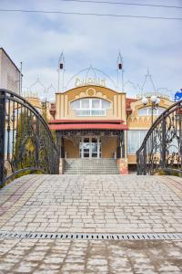a building with a gate and a brick walkway at Східний in Brzezhany