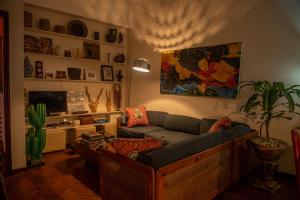 - un salon avec un canapé et une télévision dans l'établissement Guesthouse MALAGUETA INN I & II, à Maputo