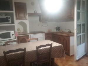 a kitchen with a table with chairs and a sink at Studio massacan in Entrevaux