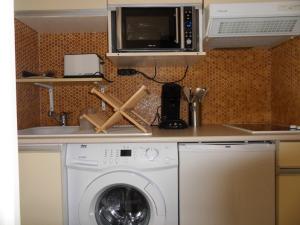 a kitchen with a washing machine and a microwave at Studio Cap Sud Capbreton proche plage in Capbreton