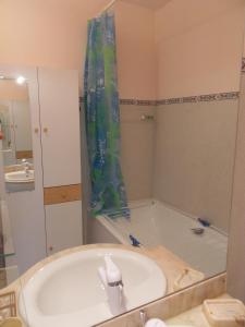 a bathroom with a tub with a shower curtain at Studio Cap Sud Capbreton proche plage in Capbreton